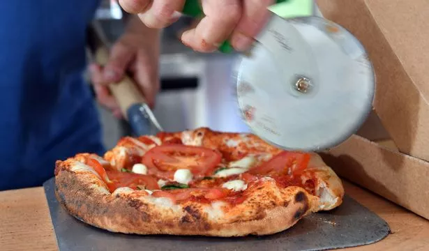 Fresh pizza being sliced